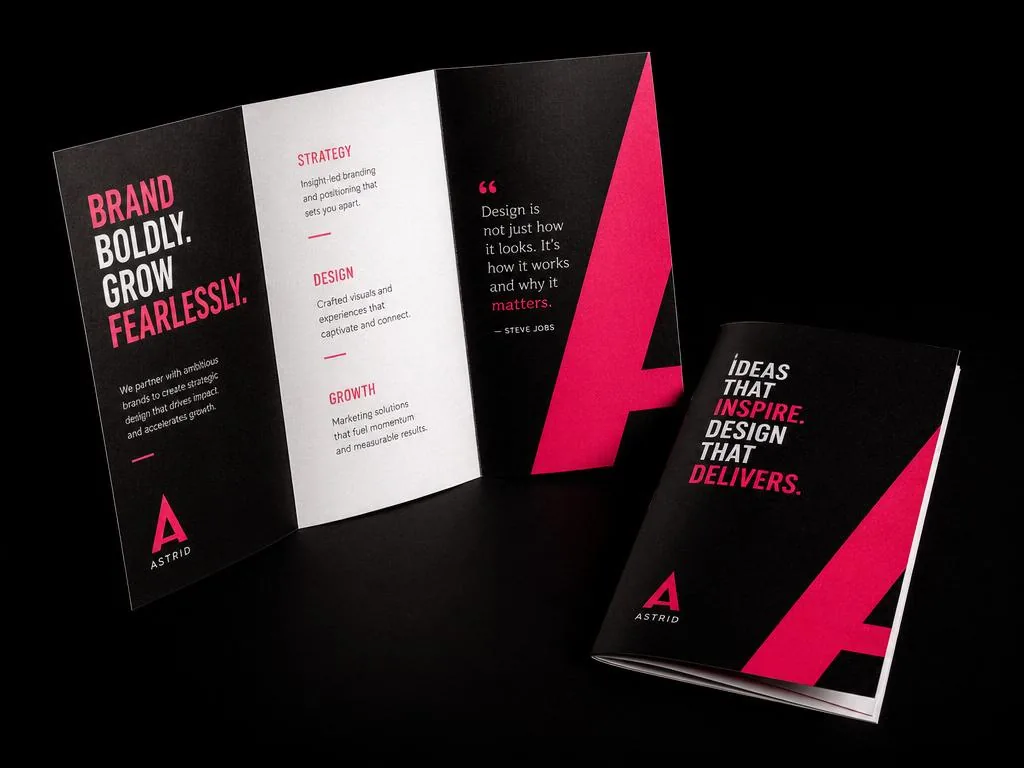 Open tri-fold brochure and booklet with bold pink and black design